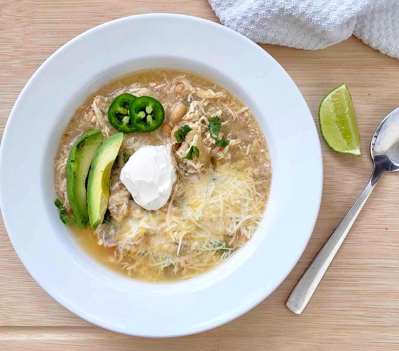 Slow Cooker White Bean Chicken Chili topped with avocado, sour cream and jalapeno peppers