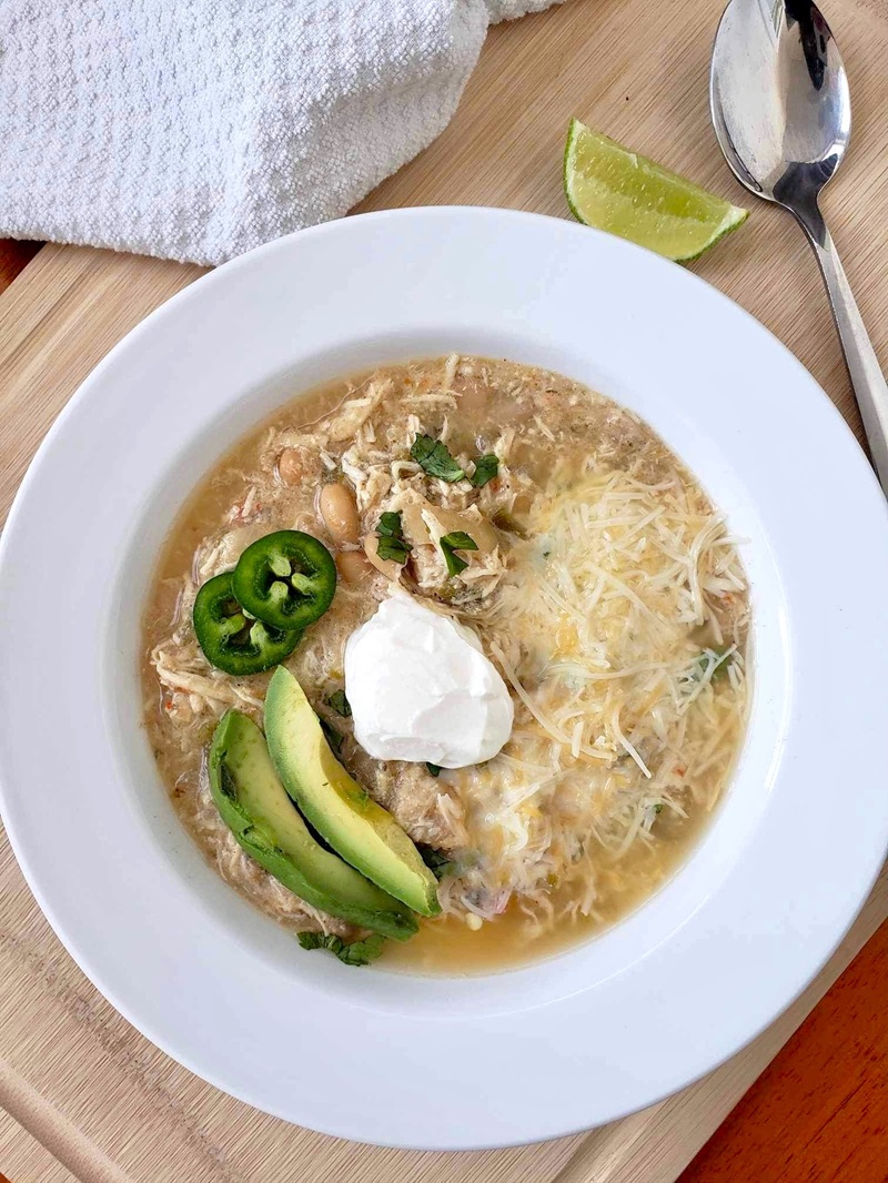 Slow Cooker White Bean Chicken Chili topped with avocado, sour cream and jalapeno peppers