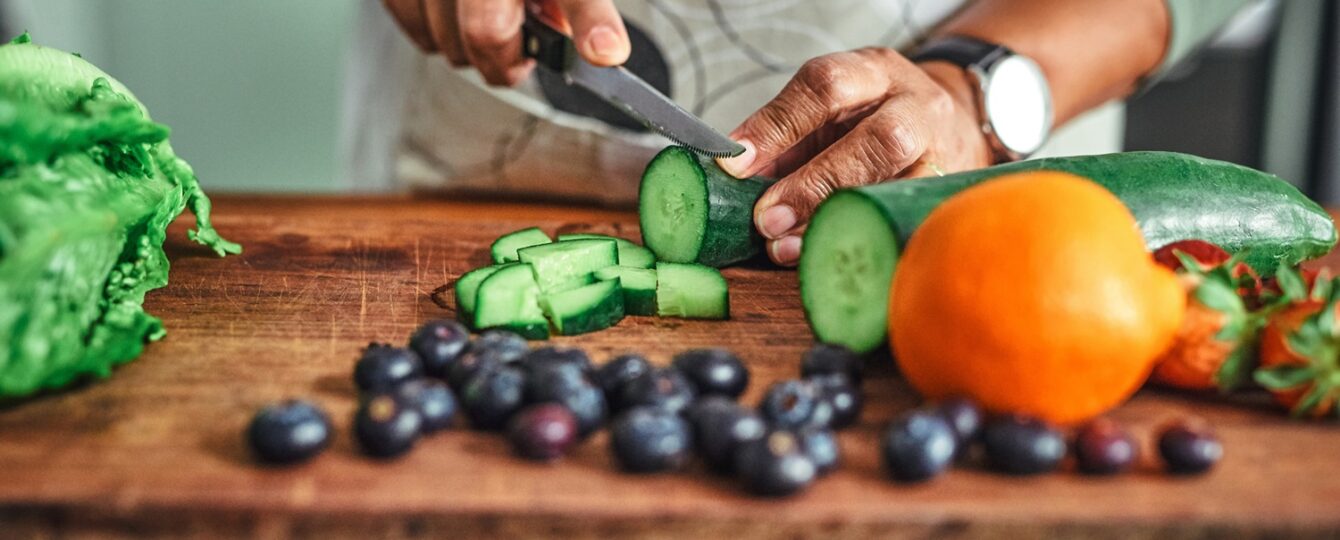 person cutting cucumbers for healthy eating plan