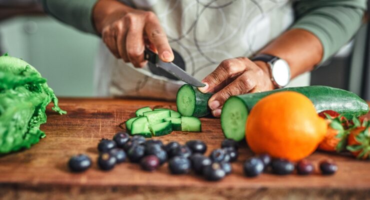 person cutting cucumbers for healthy eating plan