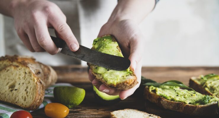 person making avocado recipes with toast