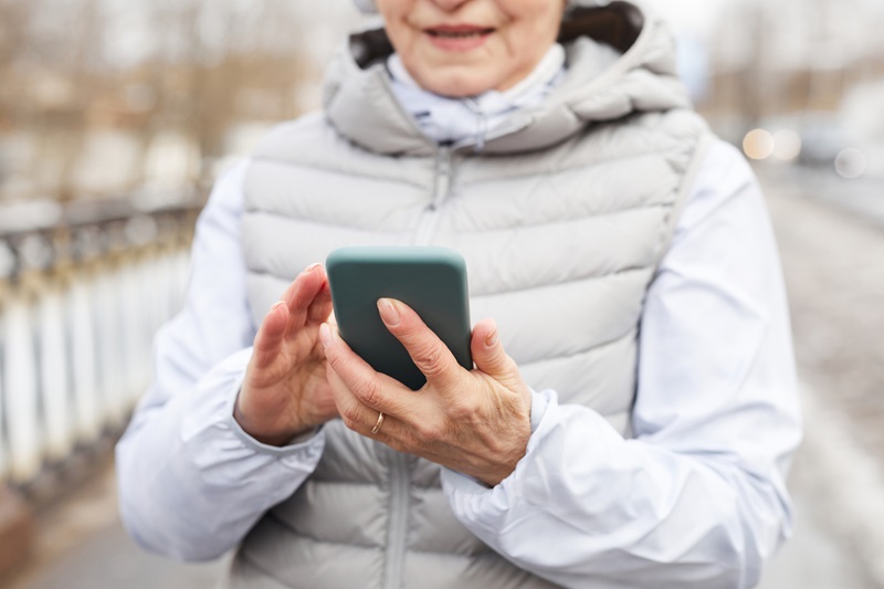 woman exercising outside in winter using a smart phone