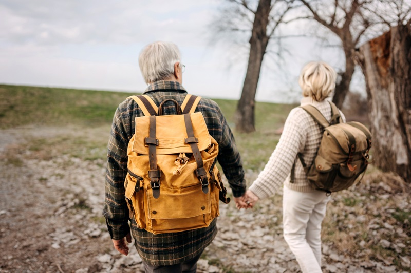 couple outside walking with backpacks