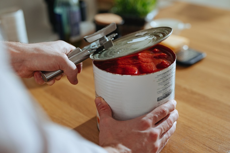 man opening a can of tomatoes