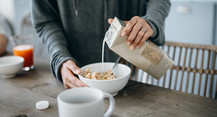 woman pouring milk into a bowl of cereal - ultra-processed foods aren't all unhealthy