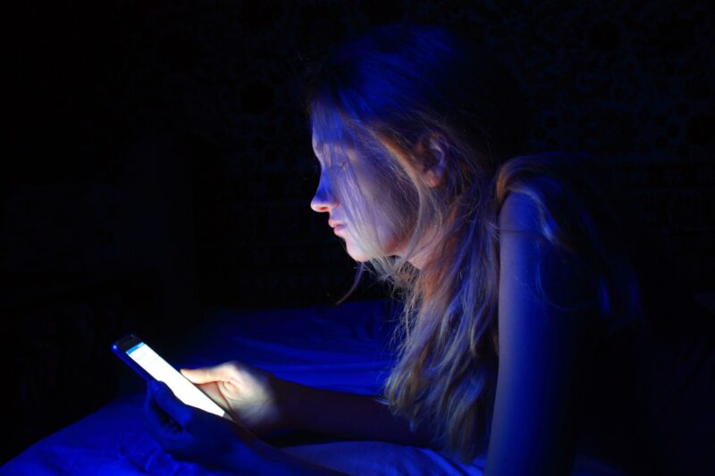woman using smart phone with blue light before sleep