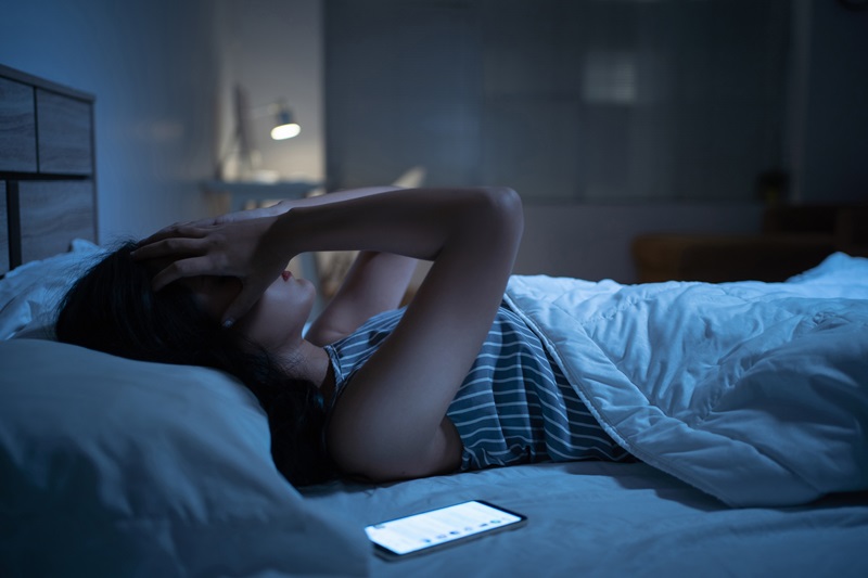 woman can't sleep because of blue light from phone