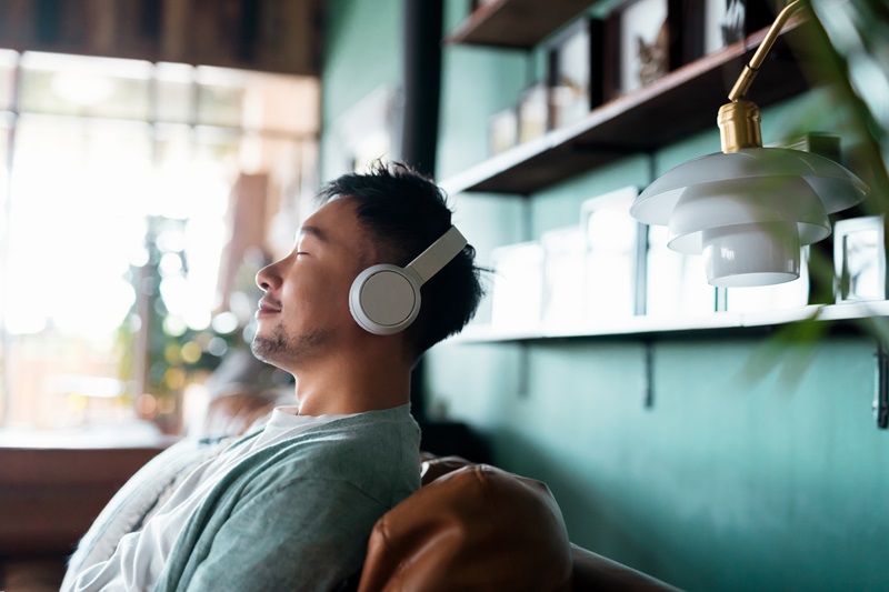 man meditating on the couch with headphones on