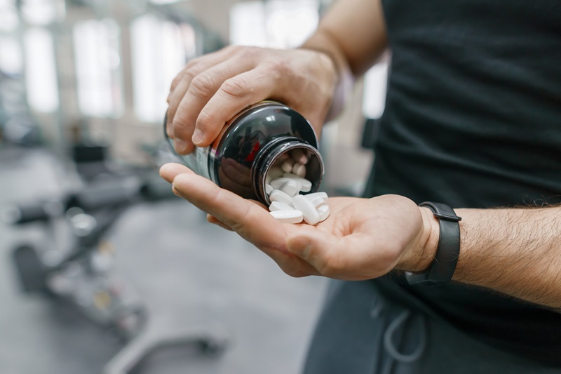 man taking supplements at the gym