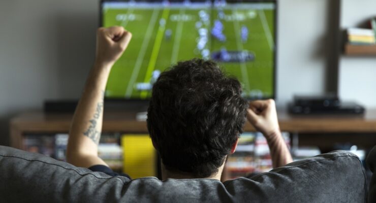 Man watching American football on tv and cheering