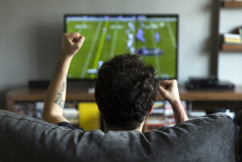 Man watching American football on tv and cheering