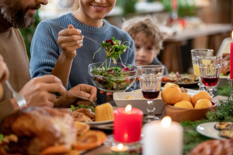 woman practicing mindful eating during the holidays serving herself salad