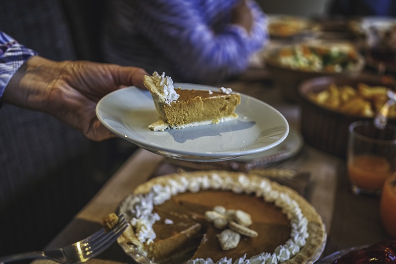 person mindful eating during the holidays enjoying a small slice of pumpkin pie