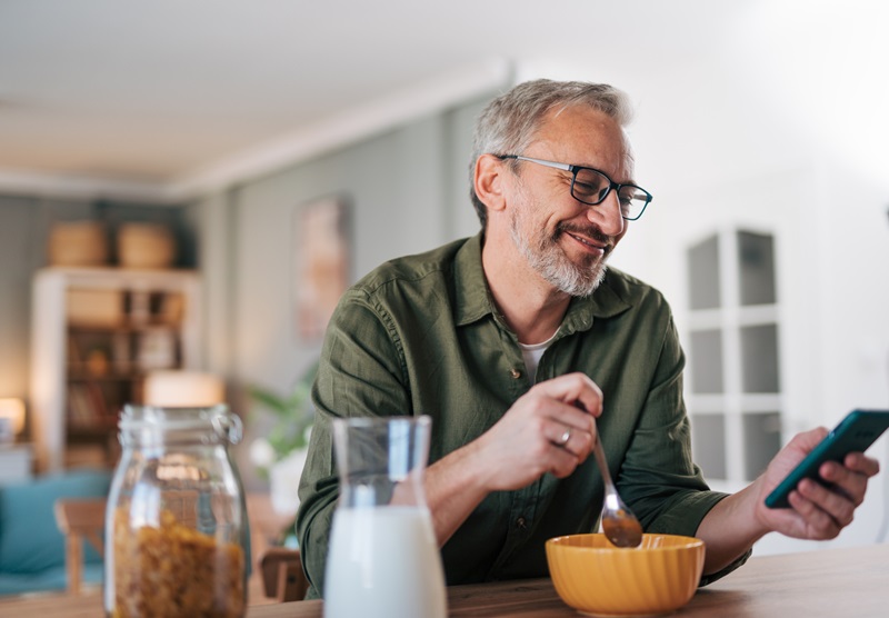 man on his phone and eating breakfast following the best diet plan for weight loss