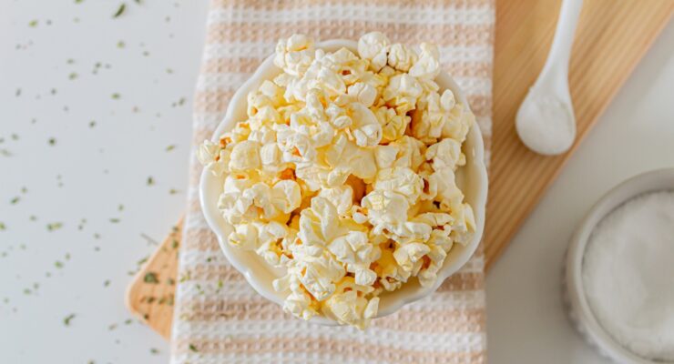 fresh air popped popcorn in a bowl surrounded by seasonings