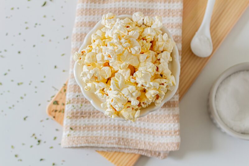 fresh air popped popcorn in a bowl surrounded by seasonings