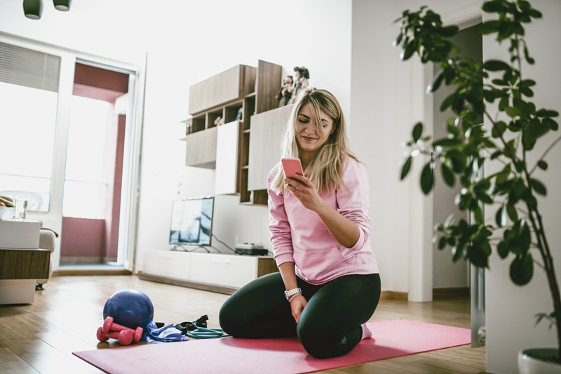 woman looking up free workouts on her phone