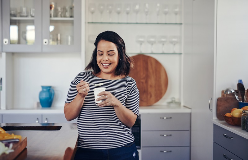 woman eating yogurt for protein snack