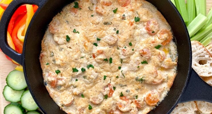 Hot Shrimp Dip surrounded by various dippers like vegetables and sliced bread