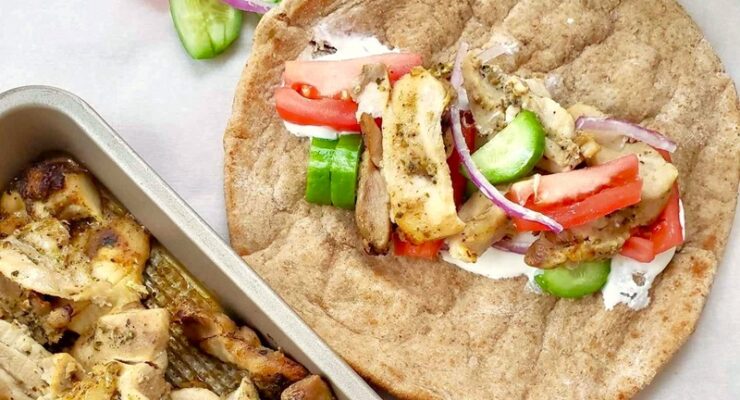 homemade chicken thigh gyro meat inside a whole wheat pita with vegetables