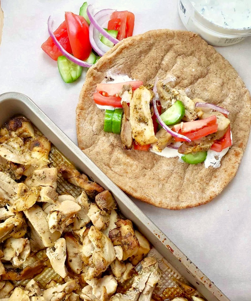 homemade chicken thigh gyro meat inside a whole wheat pita with vegetables