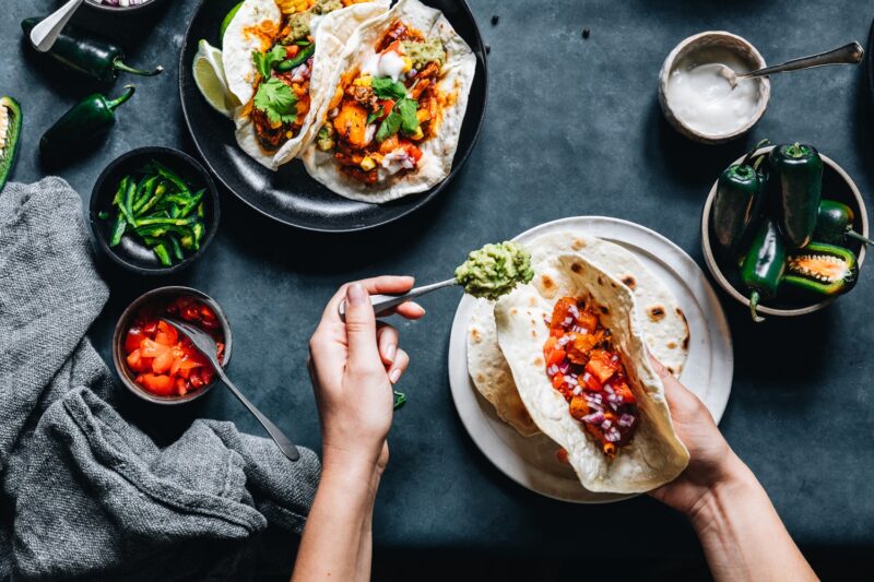 person making tacos with healthy high calorie foods like avocado