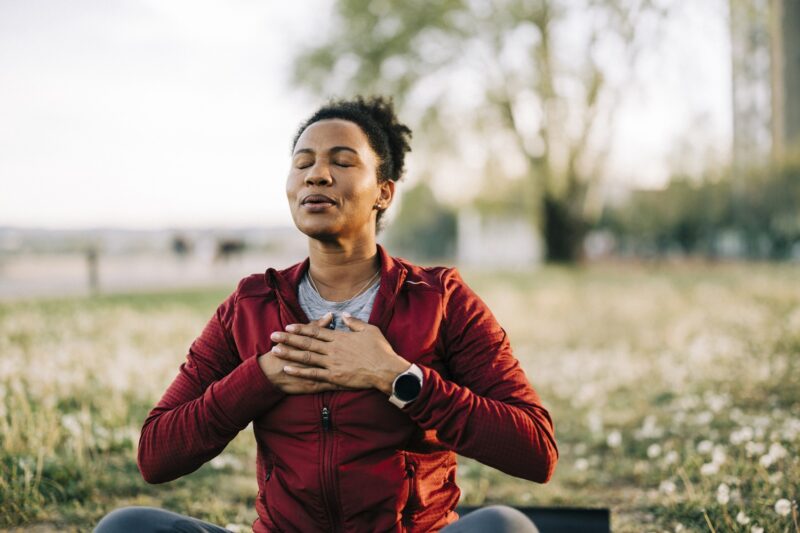 woman doing breathing exercises outside